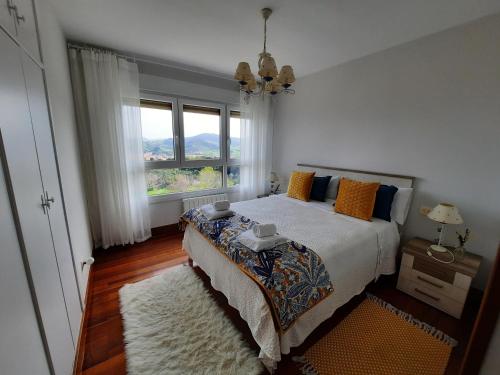 贝梅奥Gibeleburu的一间卧室设有一张床和一个大窗户