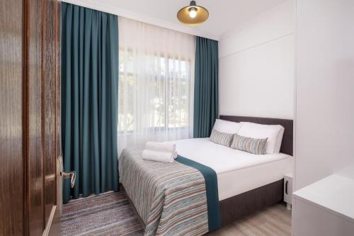 凯麦尔Sayan Apart Hotel的一间小卧室,配有床和窗户