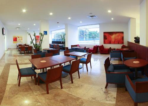 卡门城One Ciudad del Carmen Concordia的餐厅设有桌椅和沙发。