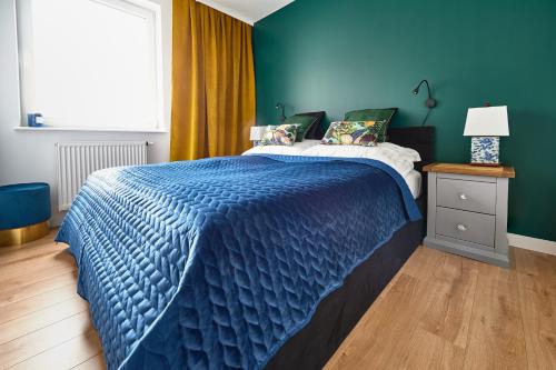 奥尔什丁Apartament Księżycowy的蓝色卧室,配有一张带蓝色棉被的床
