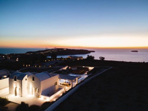 梅加洛克里Philosophia Luxury Villa的享有白色建筑的空中景色,背景是大海