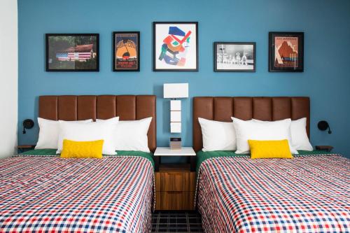 霍姆斯泰德Uptown Suites Extended Stay Miami FL – Homestead的蓝色墙壁客房的两张床