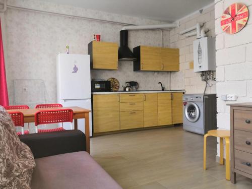 索契Апартаменты Пляж на Крымской的厨房配有冰箱和桌椅