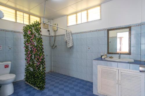 麦岛Sabai Beach Resort的一间带卫生间的浴室和墙上的植物