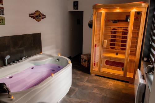 加来Aux 3 Nuances Suites Privatives & Spa的带浴缸和玻璃门的浴室