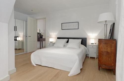 阿姆斯特丹Luxury Prinsengracht Canal House Jordan Area的白色卧室配有白色的床和两盏灯。