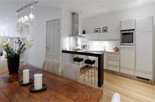 阿姆斯特丹Luxury Prinsengracht Canal House Jordan Area的白色的厨房配有桌子和用餐室