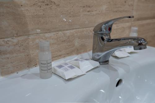 基尔科沃Стаи за гости ValenDa的浴室水槽,配有一瓶水和水龙头