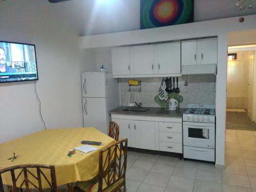 门多萨Mendoza Departamento 4 o 5 personas的厨房配有桌子和白色冰箱。