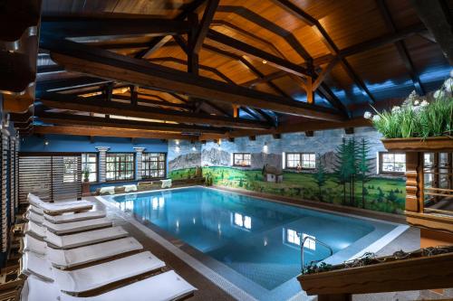 卡尔帕奇Alpejski Boutique Hotel的一座带天花板的别墅内的游泳池