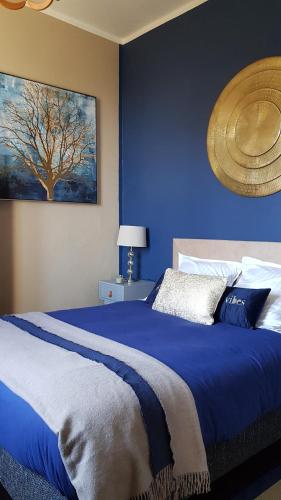 卡尼亚诺Aroma Green Villa的蓝色卧室,配有一张大床和树