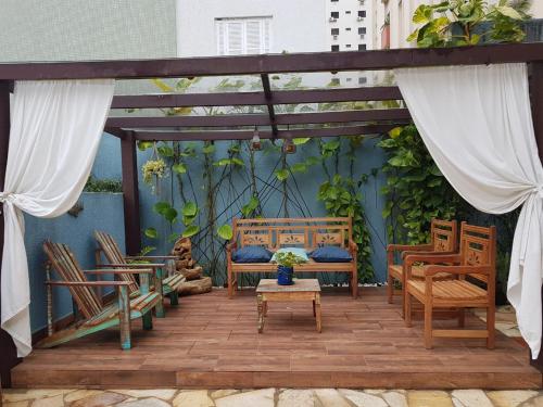 瓜鲁雅Hotel Casarão Pitangueiras的庭院配有桌椅和长凳