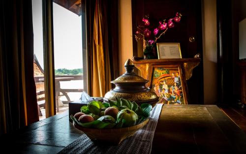 Ban Bang Krasan大城府河畔景苑酒店的花瓶,桌子上的一碗水果