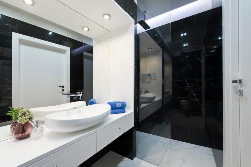 格但斯克AURA Gdansk by Q4Apartments的浴室配有白色水槽和淋浴。