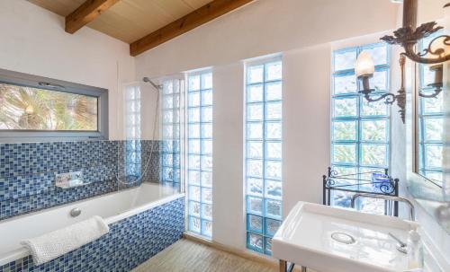 马略卡岛帕尔马Pool House的带浴缸、水槽和窗户的浴室
