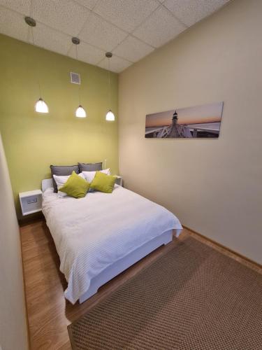 图库姆斯Center Apartments Tukums的卧室配有白色大床和绿色墙壁