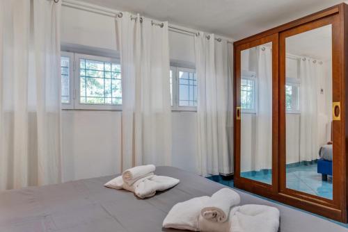 圣温琴佐InVilla Seristori, a 50 m dal mare的卧室配有带镜子的床上白色毛巾