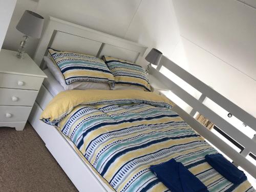 布莱顿霍夫Brighton Marina Floating home的卧室内的白色床和条纹枕头