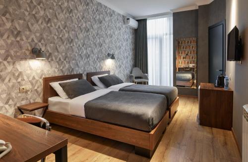 第比利斯Hotel City的一间卧室配有一张床、一张书桌和一台电视。