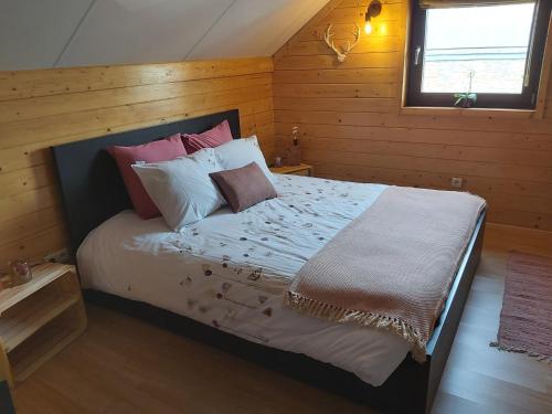 利布拉蒙Le refuge Ardennais的卧室配有带枕头的床铺和窗户。