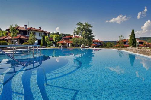奥雷沙克Марковската къща的一座大型蓝色游泳池,其背景是房屋