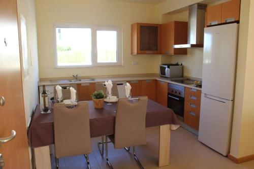 布尔高BURGUNA Apartment, 500m from Burgau Beach的厨房配有桌椅和冰箱。