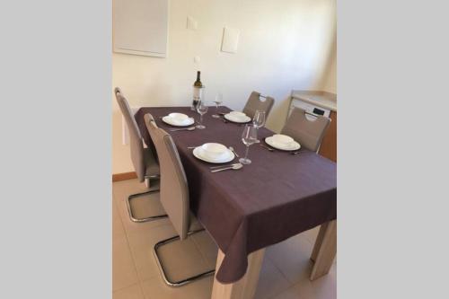 布尔高BURGUNA Apartment, 500m from Burgau Beach的餐桌、椅子和深褐色的桌布
