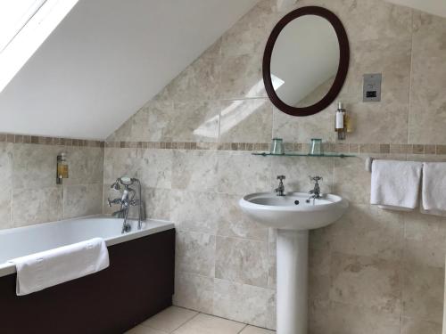 杜伦Victoria inn的一间带水槽、浴缸和镜子的浴室