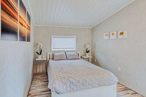 佩恩提德波斯特Modern & Cozy stand-alone apartment - perfect stay的一间卧室配有床和两张鲜花桌