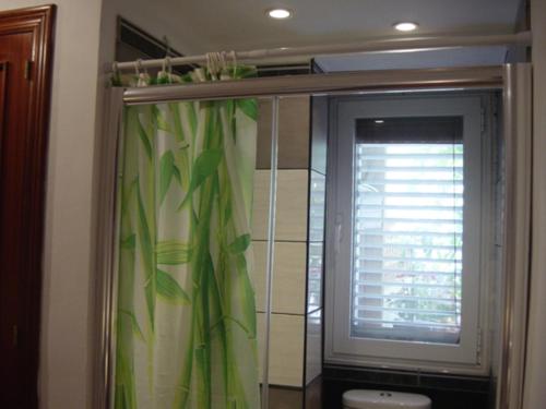 科拉雷侯Lovely CottageAurora的带淋浴帘和窗户的浴室