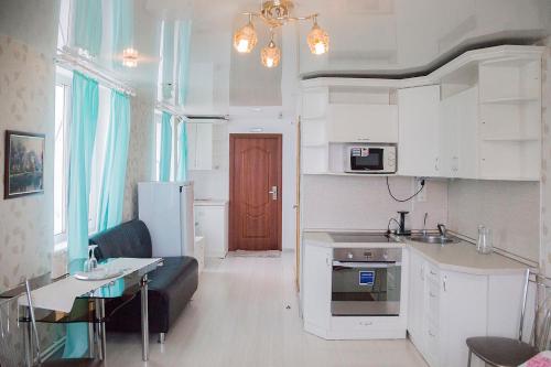 伊热夫斯克Hotel Mir的厨房以及带沙发和桌子的客厅。