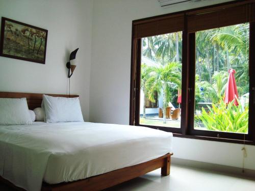 芒希Explorer Lombok from The Shared Pool For 2的一间卧室设有一张床和一个大窗户