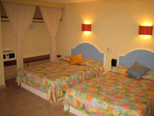 阿卡普尔科Hotel Delfines Acapulco by NG Hoteles的一间酒店客房,房间内设有两张床