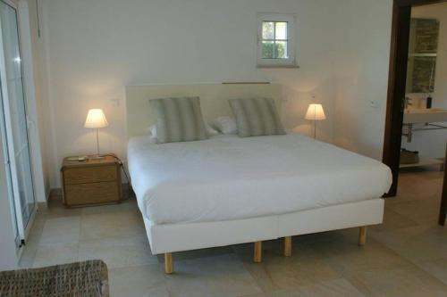奎特里拉Villa Sol Grande - Exclusive 5 Bedroom Villa - Great Pool Area - Perfect for Families的卧室配有白色的床和两盏灯。