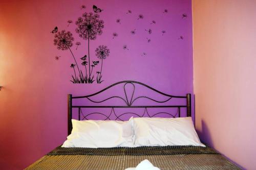 瓜拉雪兰戈Colourful homestay - (near jeti sky mirror)的一间卧室配有一张紫色墙壁的床