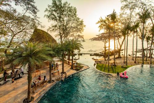 富国Ocean Bay Phu Quoc Resort and Spa的度假村的游泳池,人们乘坐木筏