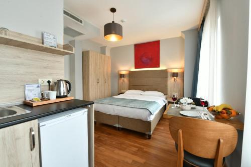 伊斯坦布尔Andi Hotel的一间卧室配有一张床,厨房配有水槽