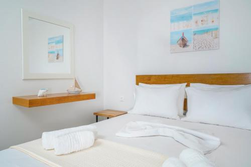 利迈纳里亚Villa Lithi的卧室配有白色的床铺和白色的枕头