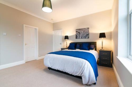 威姆斯洛Modern Living 2 Bedroom Apartment South Wilmslow的一间卧室配有一张带蓝色枕头的大床