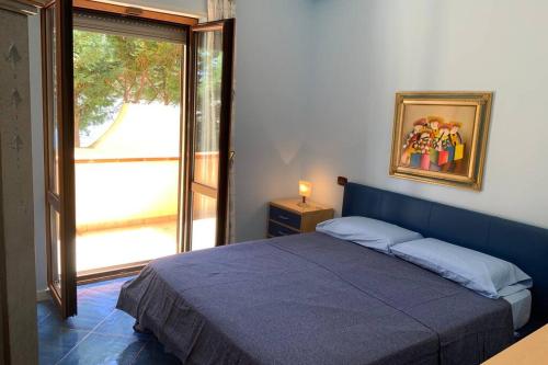 皮佐Casa Alexandr Piedigrotta的一间卧室设有蓝色的床和窗户。