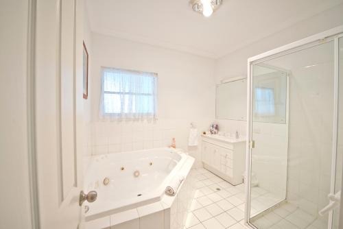 Encounter BayEncounter Hideaway Cottages的白色的浴室设有浴缸和水槽。