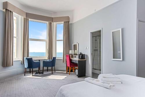 埃克斯茅斯Best Western Exmouth Beach Hotel的一间卧室配有书桌和桌椅