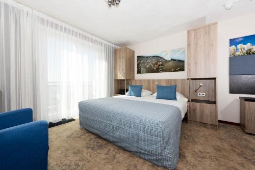 海边的艾格蒙特瓦西斯特拉德酒店的一间酒店客房,配有一张床和一台电视