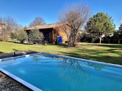 佩萨克Crisalys Chambres d'Hôtes的一座大蓝色游泳池,位于房子前