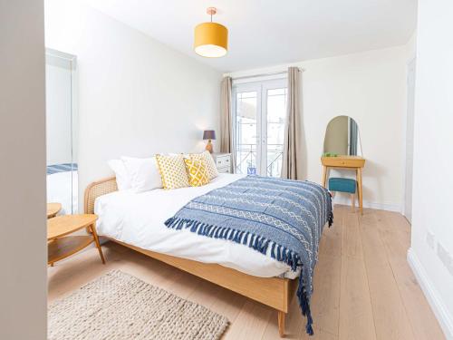 切尔滕纳姆10 Tivoli Mews - By Luxury Apartments的白色卧室配有一张带蓝色毯子的床