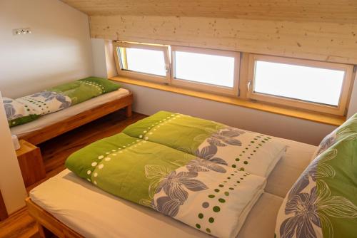 SchnepfauFerienwohnung Berchtold的小房间设有两张床和两个窗户