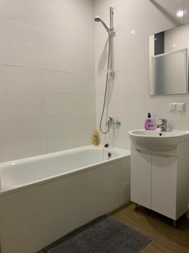 维什涅韦028 Апартаменты в ЖК "Софиевская Слободка"的白色的浴室设有浴缸和水槽。