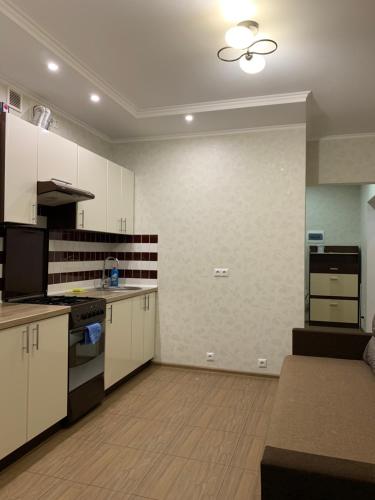 维什涅韦028 Апартаменты в ЖК "Софиевская Слободка"的厨房配有白色橱柜和炉灶烤箱。