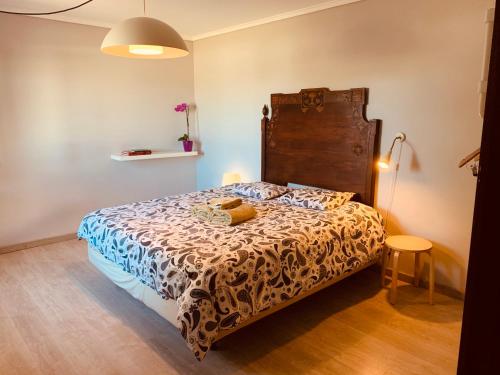 Chousa VelhaHappy Ria House的一间卧室配有一张带木制床头板的床