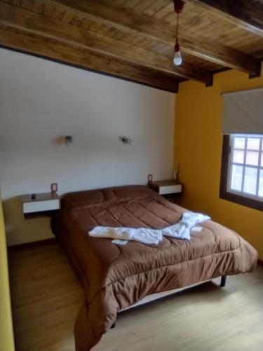 马拉圭MALARGUE STYLE,A 100 Mtrs DEL CENTRO,MUY UBICADO的一间卧室配有一张床,上面有两条毛巾